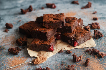 Tasty chocolate brownie with cherry. Pieces of cake on the table