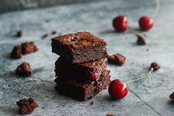 Tasty chocolate brownie with cherry. Pieces of cake on the table