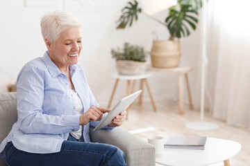 Modern Relax. Cheerful Senior Lady Using Digital Tablet At Home
