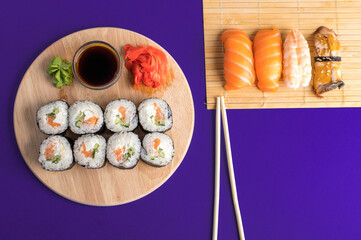 Sushi set sashimi with salmon, shrimp, eel and sushi rolls served on bamboo mat and wooden board