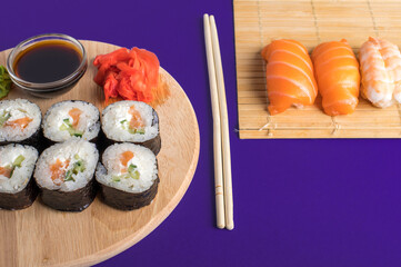 Sushi set sashimi with salmon, shrimp, eel and sushi rolls served on bamboo mat and wooden board