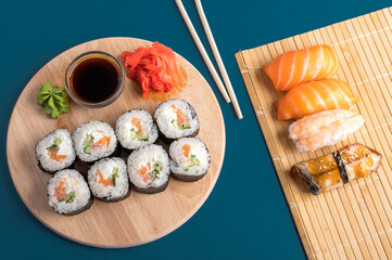 Sushi set sashimi with salmon, shrimp, eel and sushi rolls served on bamboo mat and wooden board