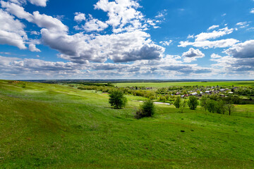 Green hills against the blue sky with clouds.