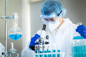 Scientist Working On Coronavirus Vaccine At Lab. 
Abstract of Analyzing covid 19 sample with microscope and holding coronavirus covid 19 blood sample tube in laboratory.