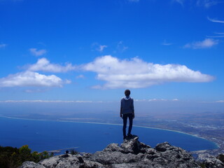 Obraz premium A woman standing on the bluffs of Table Mountain looking at the city, Cape Town, South Africa