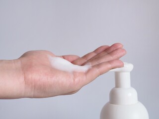 Woman hands pump liquid soap into the palm for washing hands. Personal hygiene for anti-virus and anti-bacteria in cleaning hands concept with white background.