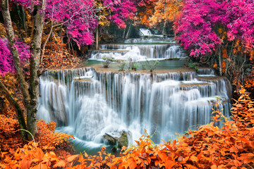 Beauty in nature, beautiful waterfall flowing of water with turquoise color of water in colorful autumn forest at fall season