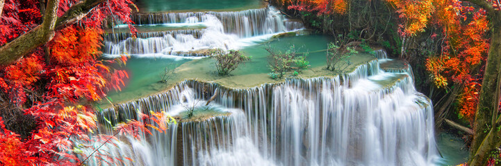 Beauty in nature, beautiful waterfall flowing of water with turquoise color of water in colorful autumn forest at fall season