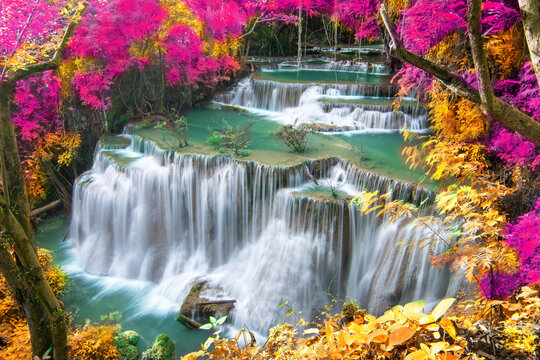 Beauty in nature, beautiful waterfall flowing of water with turquoise color of water in colorful autumn forest at fall season