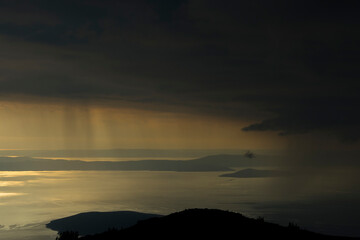 Rainy sunset above the Adriatic sea photographed from Zavizan on the Velebit mountain in Croatia. The islands Cres and Lošinj in distance.