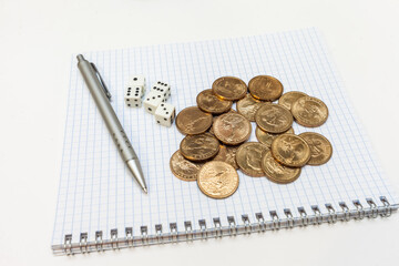 Pen, Notepad, dice, and coins on white background