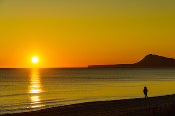 Fototapeta na wymiar Person silhouette on beach enjoy sunrise