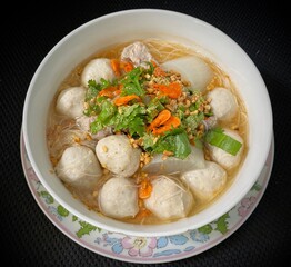 Noodle with pork ball in white bowl.