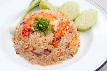 Fried rice with shrimp in white dish with seafood sauce and vegetable on the table.