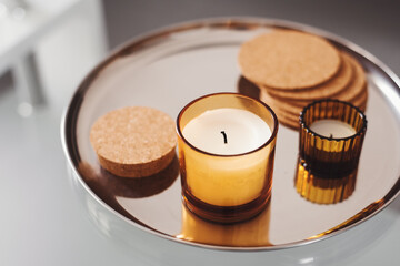Aroma candles on a round metal tray. Simple home decor. Aromatherapy concept