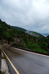 Asphalt road through the mountains forest in rainy season