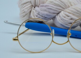 Crochet hook, yarn or wool and glasses