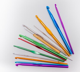 a set of colored hooks for knitting on white background