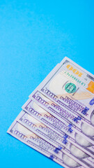 One hundred dollars on a blue background. American currency. Conceptual background of hundred dollar bills for design. Copy space