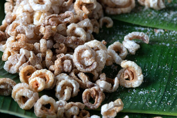 Close up of crispy pork rinds pile on banana leaf. Deep fried pork skin.