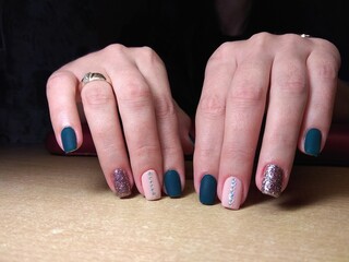 The manicurist excellently made her work a beautiful manicure with a polish gel on her hands and the client is happy
