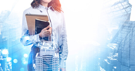 Businesswoman with notebooks in city