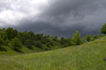 Spring hills on a background of clouds
