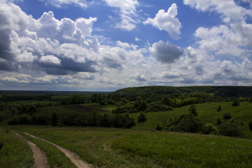 Fototapeta premium Spring hills on a background of clouds 