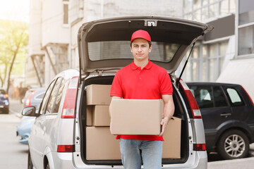 Courier goes to client, deliver parcel to home. Deliveryman near open trunk