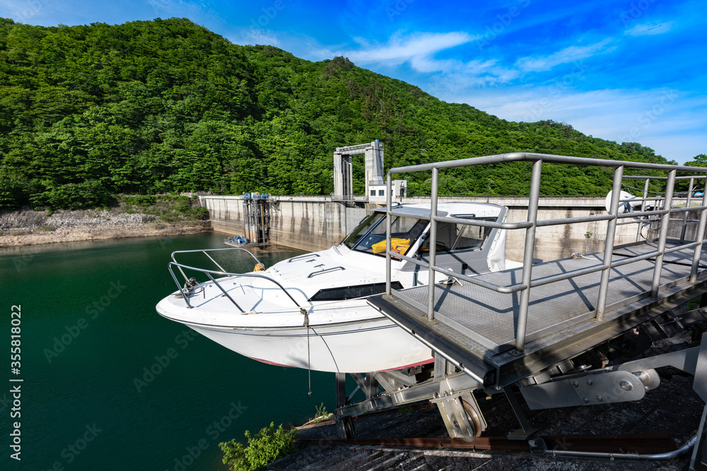 Wall mural 日本　春の栗駒ダムとエメラルドグリーンの栗駒湖と管理用船舶