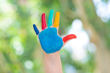 Child hands in paint isolated on green background, closeup. High quality photo