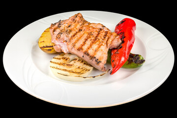 Delicious chicken steak with grilled vegetables on a white plate, isolated on black background