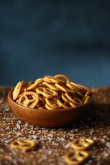 A bowl of salty cookies, on a blue background.
