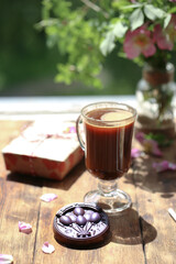 Cup of cocoa with chocolate near the window.
