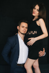 happy parents waiting for a baby. A man hugs a pregnant woman by the belly