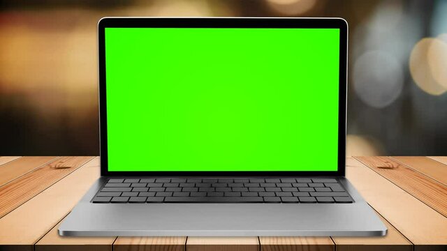 Green screen lap top on wood table in restaurant