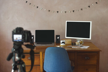 Office with black screens with portable and photo camera with tripod.