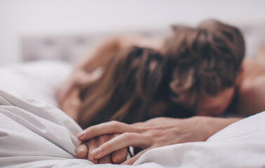 Beautiful passionate couple is having sex on bed.
