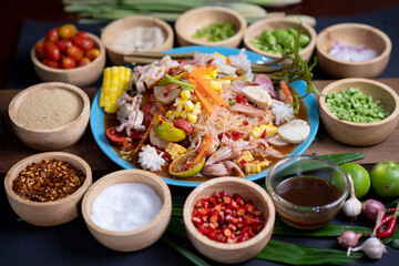 Raw rice flour in a wooden bowl with spices On a dark wood with natural light, focusing on the top of the noodles