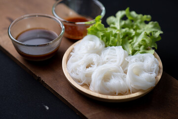 Thai Dried Rice Noodles  in wooden bowl with ingredients for delivery