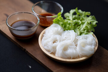 Thai Dried Rice Noodles  in wooden bowl with ingredients for delivery