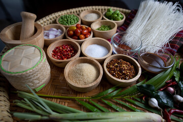 Raw rice flour in a wooden bowl with spices On a dark wood with natural light, focusing on the top of the noodles