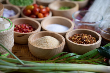 Raw rice flour in a wooden bowl with spices On a dark wood with natural light, focusing on the top of the noodles