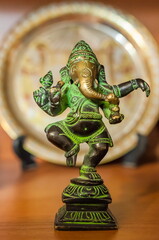 bronze figurine of Ganesha on a colored background
