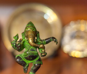 bronze figurine of Ganesha on a colored background