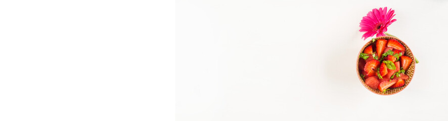 Fruit salad with strawberries, watermelon and basil leaves in ceramic bowls on white wooden table. Summer healthy snack. Copy space