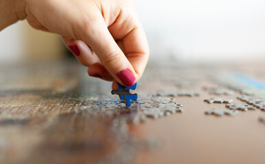 Game - Hand with pink nails while putting the puzzle together.
