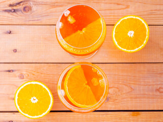 Aperol spritz cocktail on a wooden boards. Two glasses of aperol spritz with orange slised. Summer...