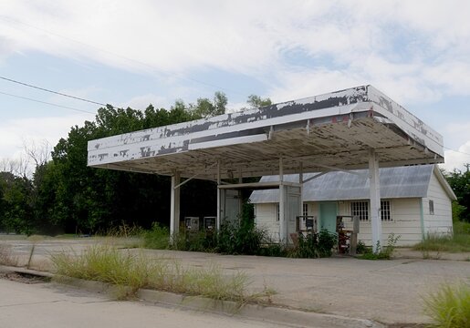 Old abandoned gasoline station with peeling paints along a countryside highway