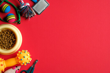 Pet store banner mockup. Flat lay accessories for cat and dog and dry food in bowl on red...